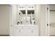 Elegant bathroom with double sinks, a large mirror, and modern fixtures at 46529 Sunflower Ln, Bennett, CO 80102