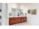 Double vanity bathroom with wood cabinets and a large mirror at 9183 Pitkin St, Commerce City, CO 80022