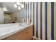 Stylish bathroom featuring blue and yellow striped wallpaper, a sink, and a large mirror at 581 Garfield St, Denver, CO 80206