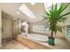 Spa bathroom featuring a soaking tub, glass shower, elegant statue, and tropical greenery at 581 Garfield St, Denver, CO 80206