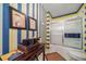 Striped bathroom featuring a shower with glass doors, blue towels, and unique artwork at 581 Garfield St, Denver, CO 80206