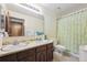 Bathroom featuring a double sink vanity with a large mirror, toilet, and shower with curtain at 4855 S Joplin St, Aurora, CO 80015