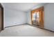 This empty bedroom features a large window with decorative curtains and neutral carpeting at 4855 S Joplin St, Aurora, CO 80015