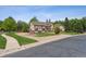 Exterior view of a distinguished home featuring a classic architectural style, well-manicured landscaping, and paved driveway at 4855 S Joplin St, Aurora, CO 80015