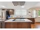 A kitchen features wood cabinets and an island with a cooktop at 4855 S Joplin St, Aurora, CO 80015