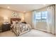 Comfortable bedroom showcasing neutral colors, floral accents, and natural light at 12354 E 101St Dr, Commerce City, CO 80022
