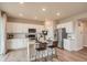 Well-lit kitchen featuring white cabinets, stainless steel appliances, and an island with bar seating at 12354 E 101St Dr, Commerce City, CO 80022