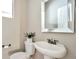 Modern half bathroom with pedestal sink, framed mirror, and neutral wall color at 15592 W Wesley Ave, Lakewood, CO 80228