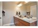 Bathroom boasting double sinks with granite counters, framed mirror, and decorative accents at 15592 W Wesley Ave, Lakewood, CO 80228