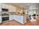 Contemporary kitchen featuring stainless steel appliances, white cabinets, granite countertops, and modern lighting at 15592 W Wesley Ave, Lakewood, CO 80228