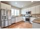 Well-lit kitchen featuring stainless steel appliances, granite countertops, and wood flooring at 15592 W Wesley Ave, Lakewood, CO 80228