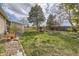 Expansive backyard featuring a lush lawn, mature trees, privacy fence, and outdoor seating with a fire pit at 6267 S Albion Ct, Centennial, CO 80121