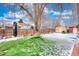 Large backyard with shed, mature tree, and snow-covered grass at 4865 Scranton Ct, Denver, CO 80239