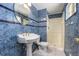 Bathroom with blue tile, pedestal sink, and shower at 4865 Scranton Ct, Denver, CO 80239