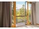 Serene view from the balcony showcasing lush trees and distant mountains under a clear sky at 32217 Buffalo Park Rd, Evergreen, CO 80439