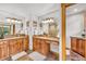Bathroom featuring dual sinks with a wood vanity, mirrors, and a tiled floor at 32217 Buffalo Park Rd, Evergreen, CO 80439