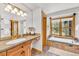 Bright bathroom featuring a soaking tub, double vanity, and natural light from the window at 32217 Buffalo Park Rd, Evergreen, CO 80439