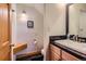Cozy half bath featuring a granite countertop and wood-look flooring, conveniently located in home at 32217 Buffalo Park Rd, Evergreen, CO 80439