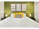 Comfortable bedroom with green accent wall, modern decor, and lots of natural light at 32217 Buffalo Park Rd, Evergreen, CO 80439