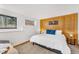 Cozy bedroom with white walls, wood accent wall, large windows, carpeted floors, and a comfortable queen-sized bed at 32217 Buffalo Park Rd, Evergreen, CO 80439