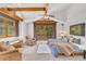 Cozy bedroom with beamed ceilings, an upholstered chair, and access to a private balcony at 32217 Buffalo Park Rd, Evergreen, CO 80439