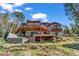 Exterior view of multilevel deck, hot tub, and home nestled in a mountainside setting surrounded by trees and greenery at 32217 Buffalo Park Rd, Evergreen, CO 80439