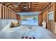 An unfinished garage featuring a large opening with a winter view, a seating bench and a concrete floor at 32217 Buffalo Park Rd, Evergreen, CO 80439