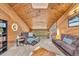 Cozy living room features a lofted beamed ceiling and comfortable furniture at 32217 Buffalo Park Rd, Evergreen, CO 80439