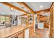 Open concept living space with wood beams, stone fireplace, and eat-in kitchen with barstool seating at 32217 Buffalo Park Rd, Evergreen, CO 80439
