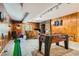 Finished basement recreation room with foosball table, stone fireplace, wood paneled walls, and carpeted flooring at 32217 Buffalo Park Rd, Evergreen, CO 80439