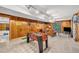 Finished basement recreation room with foosball table, wood paneled walls, carpeted flooring, and access to outside at 32217 Buffalo Park Rd, Evergreen, CO 80439