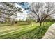 Landscaped backyard showcasing trees and a greenbelt; a pathway leads to the open space at 1438 Stockton Dr, Erie, CO 80516