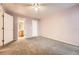 Spacious carpeted bedroom with ensuite bathroom features a ceiling fan and fresh paint at 1648 S Cole St # A2, Lakewood, CO 80228