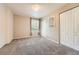 Carpeted bedroom with neutral paint, window with blinds, and double-door closet at 1648 S Cole St # A2, Lakewood, CO 80228