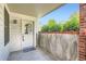A welcoming entrance with a white door, a small patio, and a view of greenery at 1648 S Cole St # A2, Lakewood, CO 80228