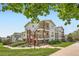 Exterior view of a well-maintained apartment building with brick accents, landscaping, and a clear blue sky at 1648 S Cole St # A2, Lakewood, CO 80228