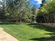 Expansive, well-maintained backyard with healthy lawn, mature trees, and stone accents, perfect for outdoor activities at 5773 S Benton Way, Littleton, CO 80123