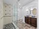 This bathroom has a glass shower with river rock floor, tiled floor, and double vanity with granite countertops at 5773 S Benton Way, Littleton, CO 80123