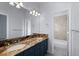 Bathroom with double vanity and granite countertop, and a view of a shower-tub combo at 5773 S Benton Way, Littleton, CO 80123