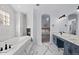 This primary bathroom features a tub, fireplace, marble tile, and blue cabinets at 5773 S Benton Way, Littleton, CO 80123