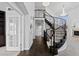Grand foyer with a curved staircase, dark wood floors, and elegant chandelier lighting at 5773 S Benton Way, Littleton, CO 80123