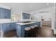 This kitchen boasts blue cabinetry, an island with seating, and stainless steel appliances at 5773 S Benton Way, Littleton, CO 80123