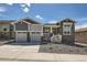 Charming home featuring gray stone and siding, a two-car garage, and a beautifully landscaped front yard at 651 Scrubjay Cir, Castle Rock, CO 80104