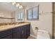 Bathroom featuring granite countertop vanity, mirror, and tiled shower at 2380 W 105Th Pl, Northglenn, CO 80234