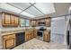Well-lit kitchen with tile floors, wood cabinets and black appliances at 2380 W 105Th Pl, Northglenn, CO 80234