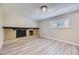 Spacious living room featuring a brick fireplace, new flooring, and a bright window at 2380 W 105Th Pl, Northglenn, CO 80234