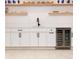 Finished basement bar area with white cabinets, a beverage center, and floating shelves at 619 S Gilpin St, Denver, CO 80209