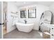 Bright bathroom featuring tile flooring, modern tub, and a large mirror at 619 S Gilpin St, Denver, CO 80209