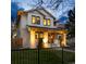Charming two-story home with inviting front porch and manicured lawn at twilight at 619 S Gilpin St, Denver, CO 80209