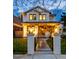 Charming two-story home featuring a manicured lawn, black iron fence, and inviting front porch with elegant lanterns at 619 S Gilpin St, Denver, CO 80209
